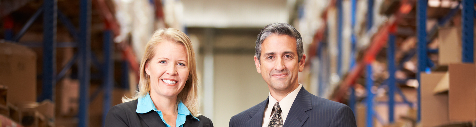 Smiling business professionals in a warehouse environment