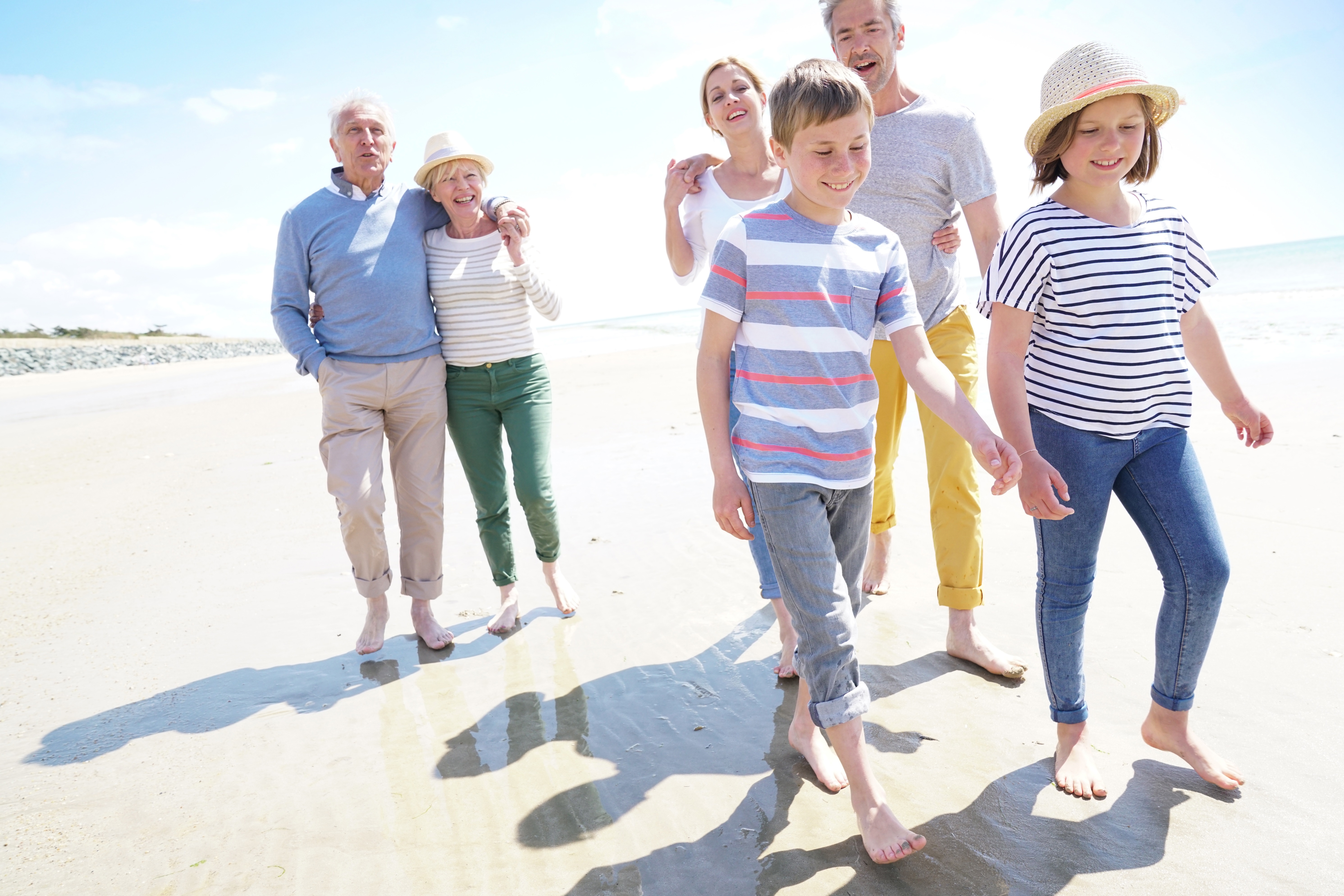 Three generations of a loving family enjoying a leisurely stroll on the beach